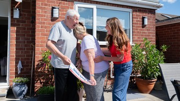 Barry hugs his wife Dot after collecting a cheque for £200,000
