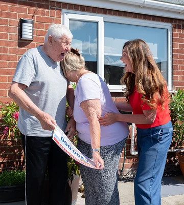 Barry hugs his wife Dot after collecting a cheque for £200,000
