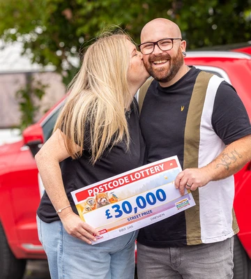 THIRTY THOUSAND SMACKERS: Mark gets a kiss from Michaela after receiving his cheque