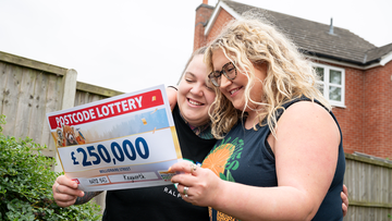 Couple Lilly and Sophie happy with the cheque for £250,000