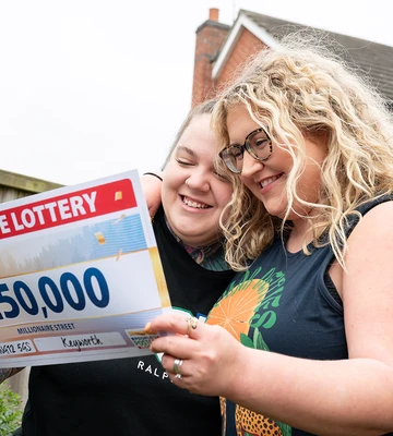 Couple Lilly and Sophie happy with the cheque for £250,000