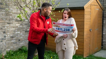A Postcode Lottery ambassador showing the winner the cash prize