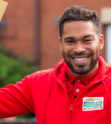Danyl Johnson holding a big envelope and smiling
