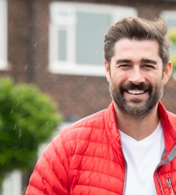 Matt Johnson standing and smiling in the rain