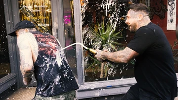 Jake is soaked with champagne by tattooist mate Tommy