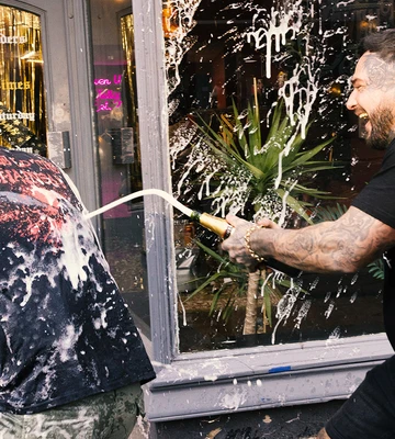 Jake is soaked with champagne by tattooist mate Tommy