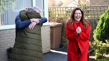 CUDDLE UP: Lesley and Robin fall into each other's arms with cheque